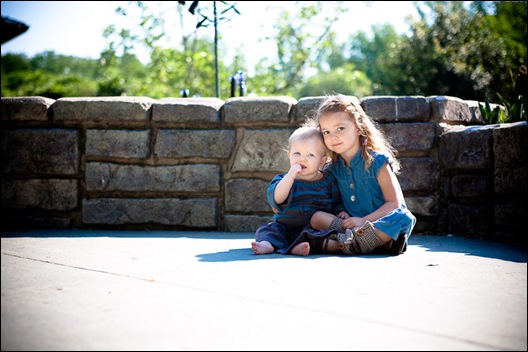 children sisters sitting in front of wall at brookside gardens in maryland
