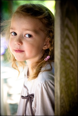 child peeking out from behind pole for a photograph at brookside gardens in maryland