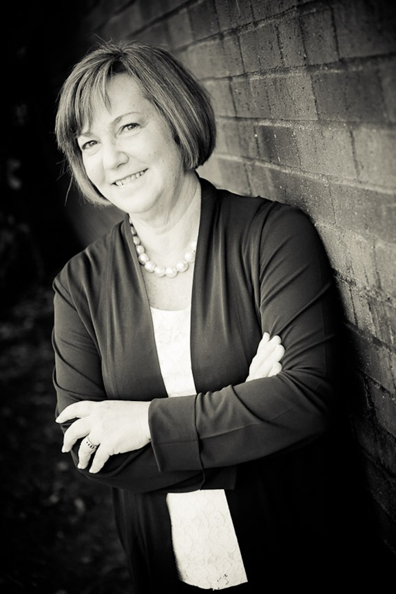 Eileen Kugler standing by wall for business portrait in downtown alexandria va