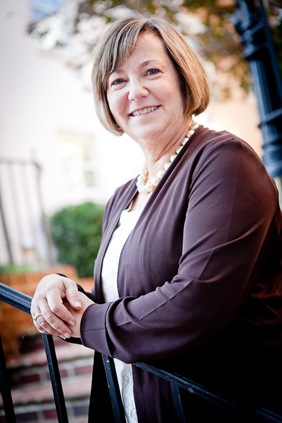 Eileen Kugler leaning on railing for business portrait in downtown alexandria va