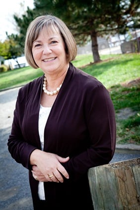 Eileen Kugler leaning on pole for business portrait in downtown alexandria va