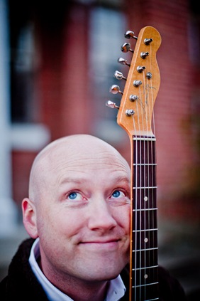 Randy Morser holding his guitar up to his face
