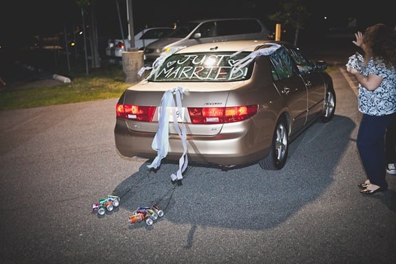 bride and groom drive away after wedding