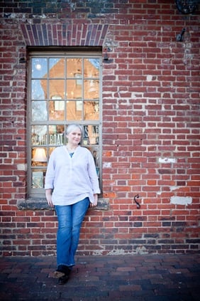 woman leaning up against window in old town alexandria