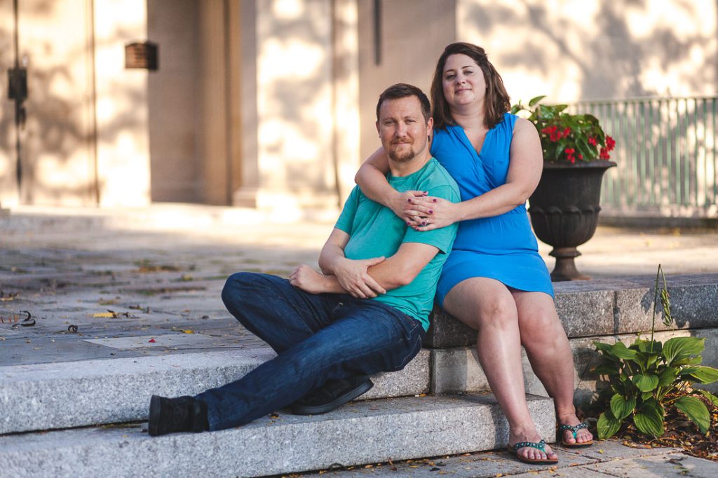 A man and a woman sitting on steps in front of a building.