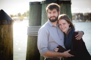 A couple embracing in front of a dock during their Engagement Session in Downtown Annapolis.