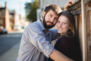 A couple leaning against a wooden fence in Downtown Annapolis.