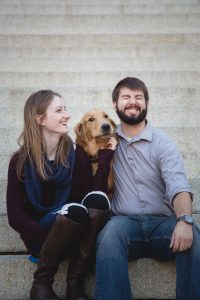 A couple sitting on steps with their dog in downtown Annapolis, capturing a beautiful engagement photo.