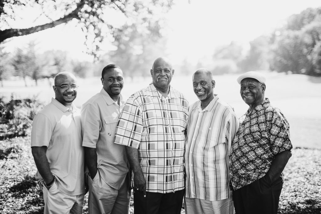 Black and white photo of a group of men posing for a photo.