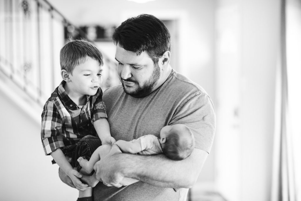 A black and white photo of a man holding a baby.
