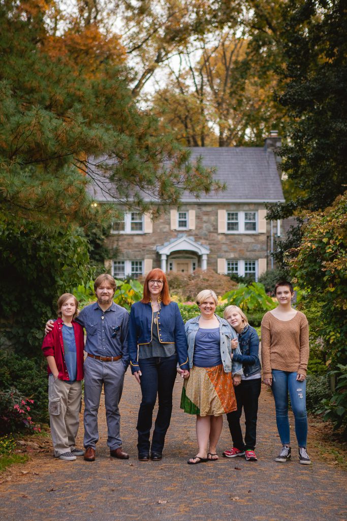 A family posing for a photo in front of a house.