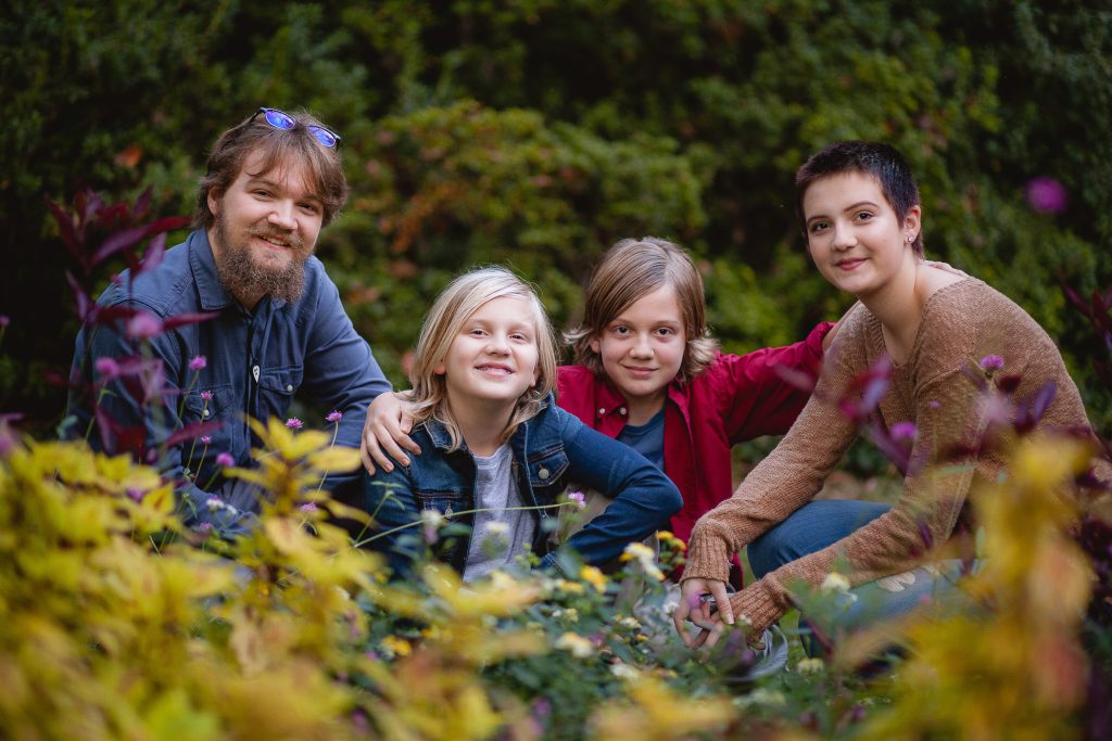 A family posing for a photo in a garden.