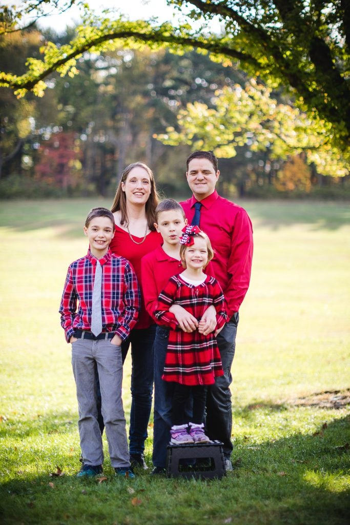 A family posing in front of a tree.