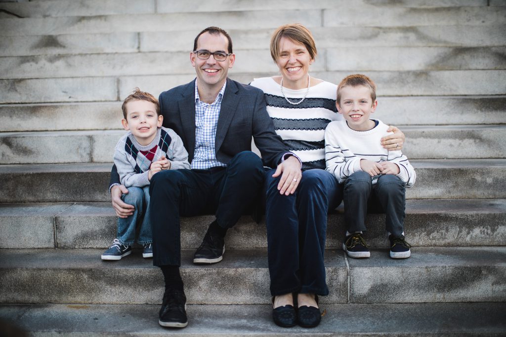 A family sits on the steps of a building.
