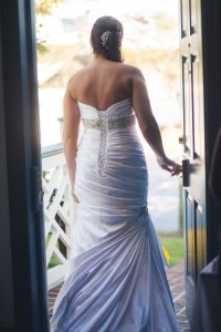 A Maryland wedding photographer captures a bride standing in a doorway in her wedding dress.
