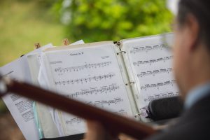 A man in a suit is playing an acoustic guitar for Maryland Wedding Photography.