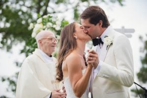 A bride and groom share a heartfelt kiss captured by their wedding photographer.