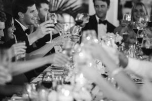 A black and white photo of people toasting wine glasses captured by a Maryland wedding photographer.