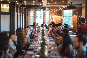Maryland wedding photographer capturing a group of people at a long table in a restaurant.