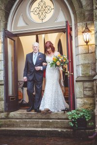 A bride and her father leaving a wedding ceremony at a church.