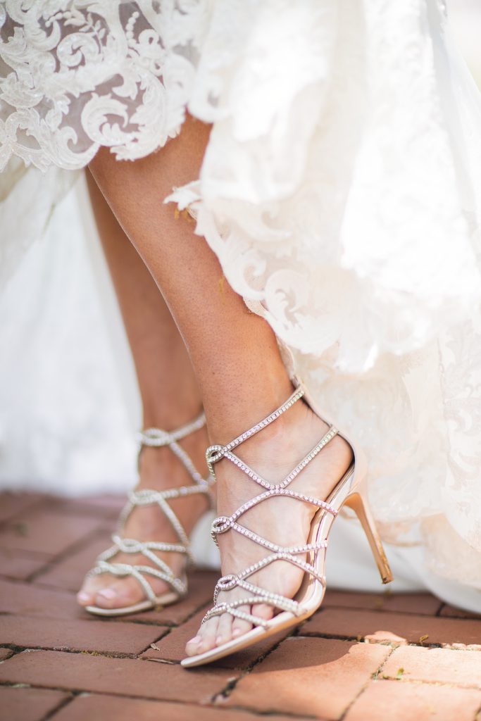 A bride's wedding shoes on a walkway.