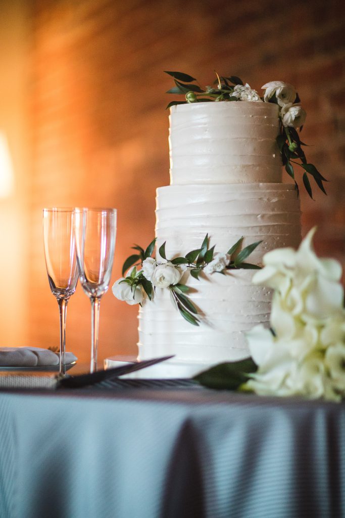 A wedding cake sits on a table adorned with intricate details.
