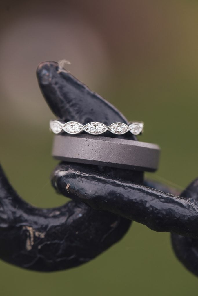 A detailed wedding ring placed on a metal surface.