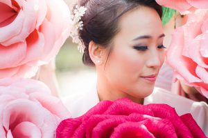 A bride is surrounded by pink roses at her wedding.