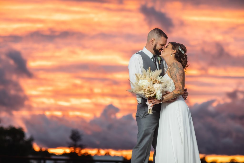 A newlywed couple shares a romantic kiss during their wedding ceremony.
