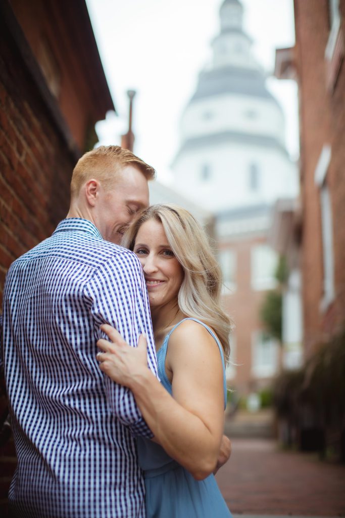A couple embraces in front of the capitol building for their engagement photo.