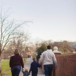 A family enjoying a leisurely stroll through Quiet Waters Park during an engagement session.