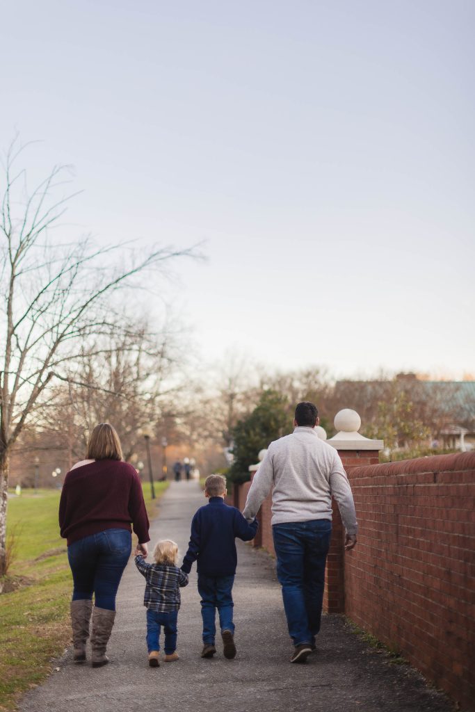 A family enjoying a leisurely stroll through Quiet Waters Park during an engagement session.