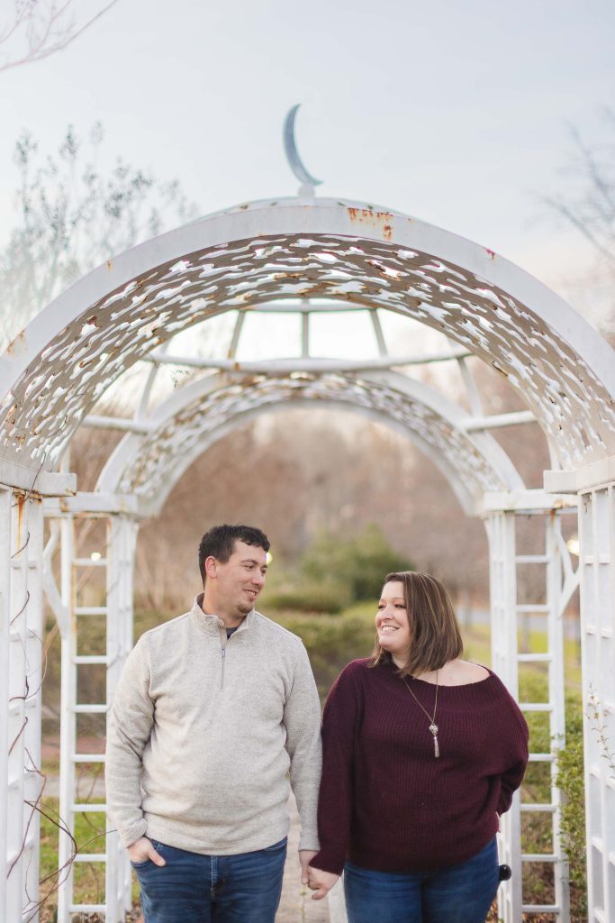 A couple holding hands under a gazebo in Quiet Waters Park.