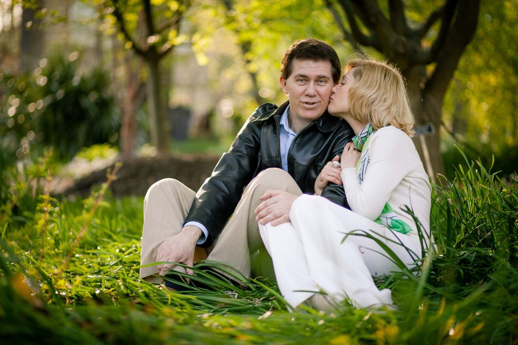 A couple is enjoying a romantic moment in the grass at Wheaton, Brookside Gardens in Maryland.
