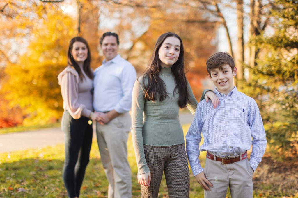A family is posing for holiday portraits in the park.