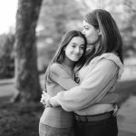 A black and white photo capturing a heartwarming moment of a mother embracing and hugging her daughter, radiating the essence of family.