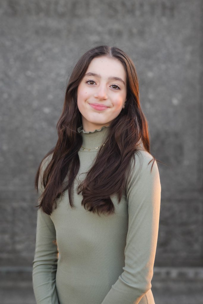 A young woman in a green top posing for a family photo.