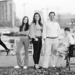 A black and white photo of a family posing on a bench in Federal Hill Park.