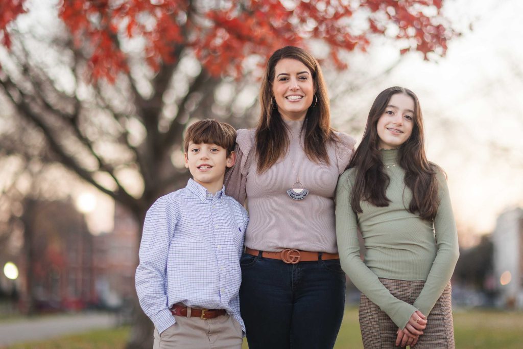 A woman and her family standing in front of a tree during a holiday celebration in Baltimore.