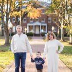 A family portrait in front of a brick house.