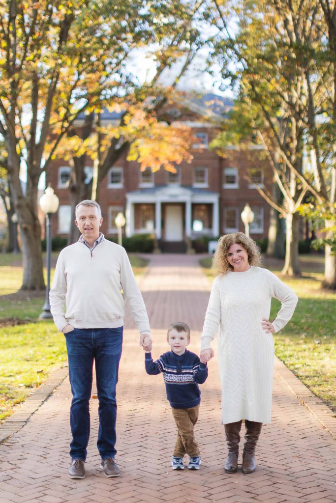 A family portrait in front of a brick house.