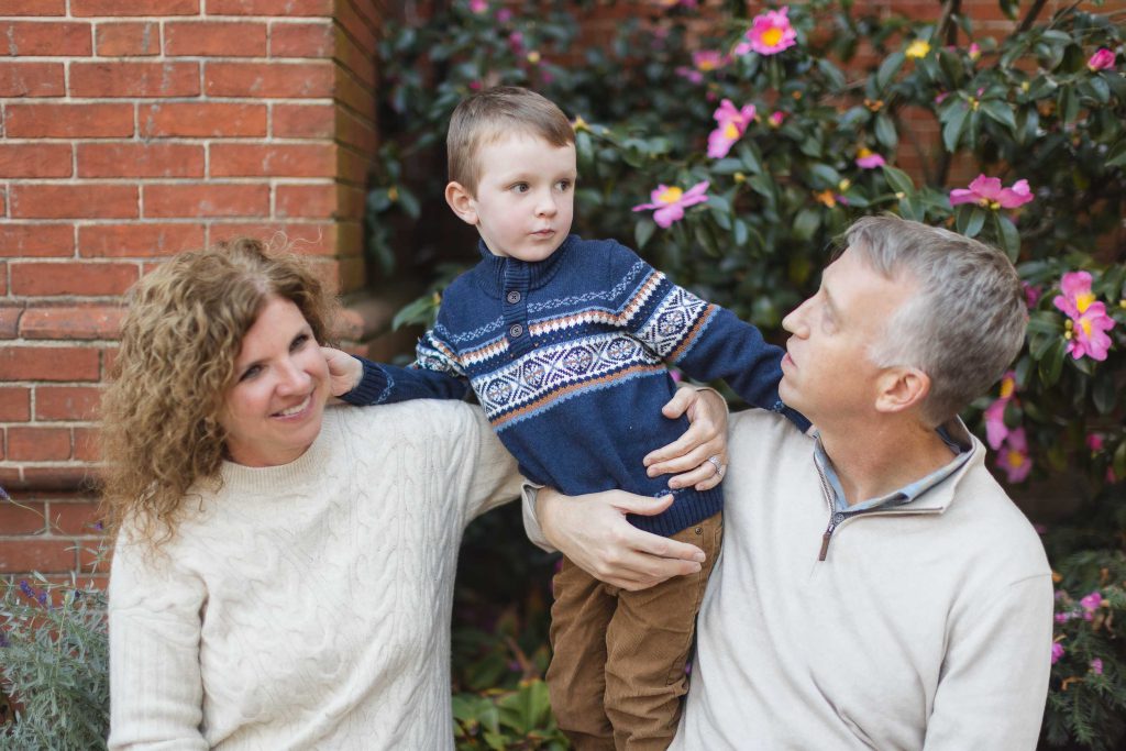 A Family poses in front of a brick wall for their Downtown Annapolis portrait.