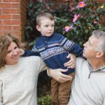A Family poses in front of a brick wall for their Downtown Annapolis portrait.