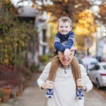A family portrait in downtown Annapolis, with an older man carrying a young boy on his shoulders.