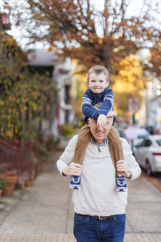A family portrait in downtown Annapolis, with an older man carrying a young boy on his shoulders.