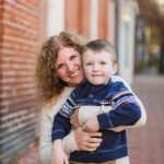 A family is posing for a portrait in front of a downtown Annapolis building.