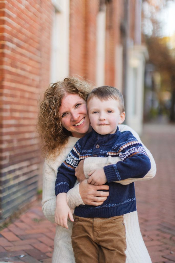 A family is posing for a portrait in front of a downtown Annapolis building.