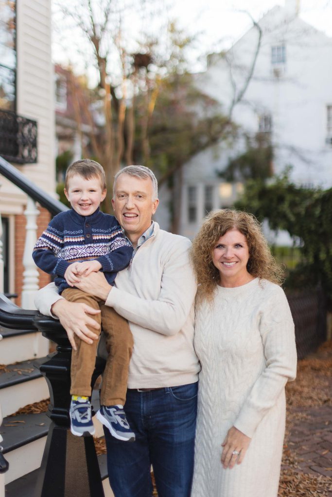 A Downtown Annapolis family posing for a portrait in front of a house.
