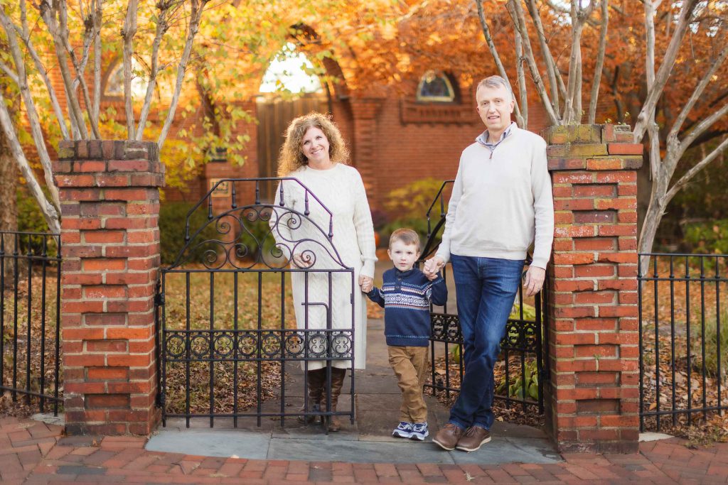 A family stands in front of an iron gate in Downtown Annapolis, posing for a beautiful portrait.