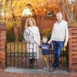 A family stands in front of an iron gate in Downtown Annapolis, posing for a beautiful portrait.